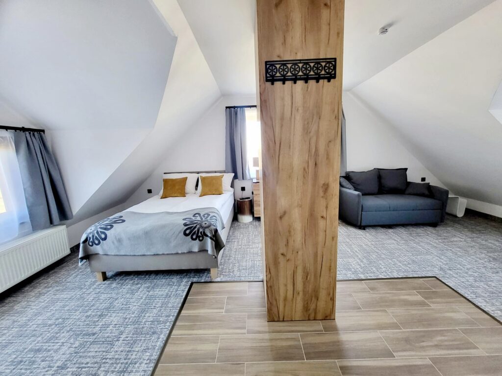 Złoty Widok room – bed, sofa and wooden column