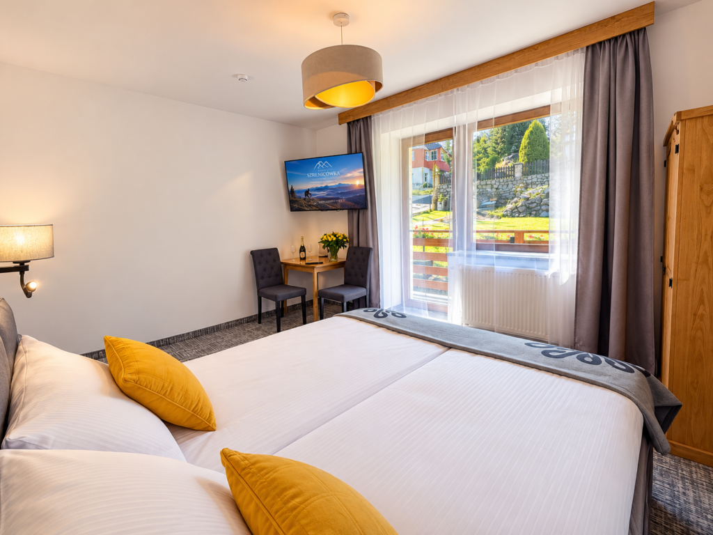Zimmer Kamieńczyk – Bett am Fenster und Tisch mit TV