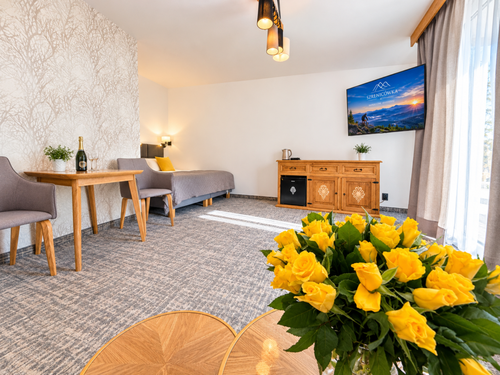 Zimmer Szrenica – Tisch mit Stühlen, Bett und Kommode mit TV