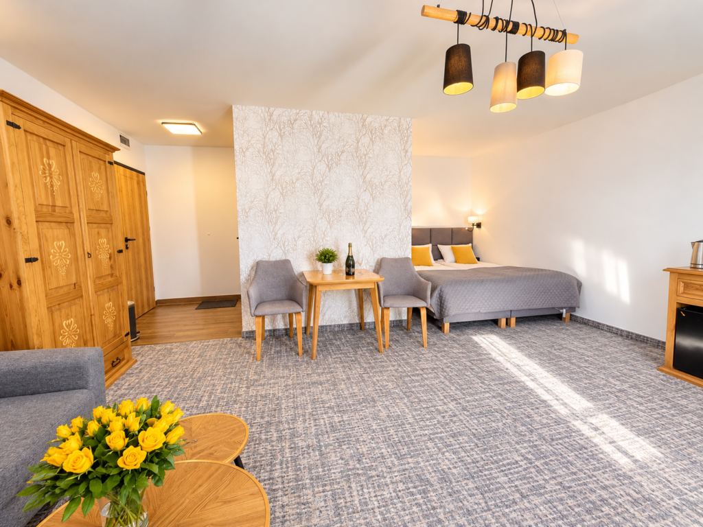 Zimmer Szrenica – geräumiger Raum mit Kleiderschrank, Tisch und Bett